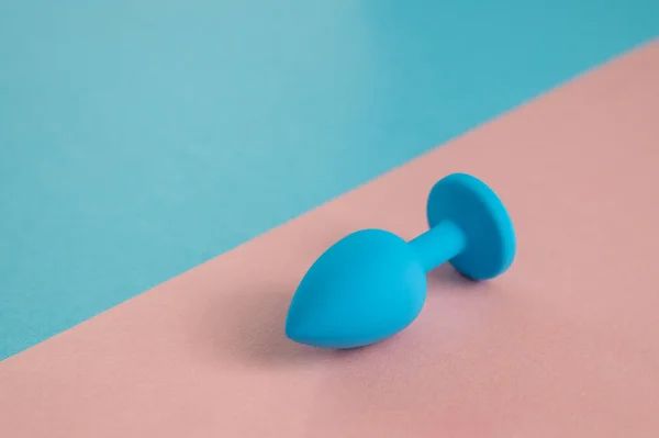 Plug anal azul sobre fondo rosa. Juguete sexual plástico para sexo alternativo. Copiar espacio. — Foto de Stock