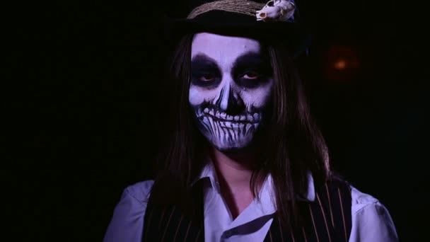 Junger Mann mit Totenkopf-Make-up im Dunkeln. Skelettkostüm zu Halloween — Stockvideo