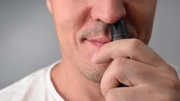 Muž si stříhá chlupy v nose kapesním střihačem — Stock video