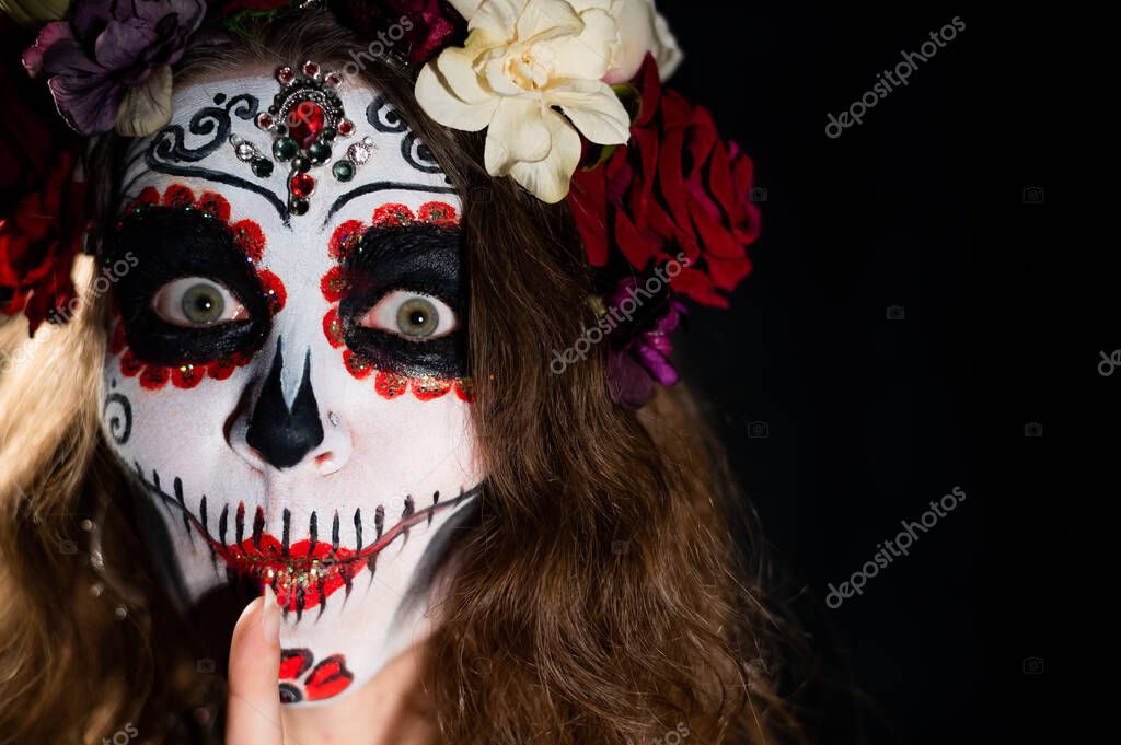 Donna in Santa Muerte trucco su uno sfondo nero. Ragazza che