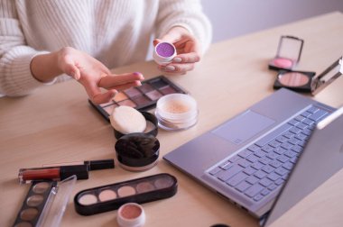 Yüzü olmayan bir kadın dizüstü bilgisayardaki profesyonel bir makyaj sanatçısından online eğitim izliyor. Uzaklık öğrenimi