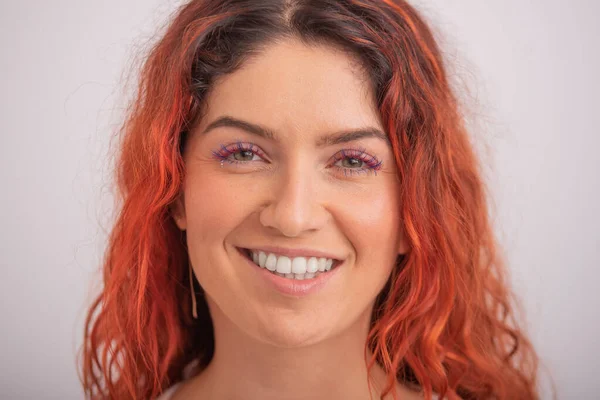 Porträtt av kaukasiska rödhårig kvinna med färgade ögonfransar på vit bakgrund. — Stockfoto
