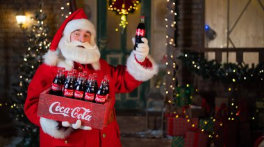 06.11.2020 Rusya, Novosibirsk: Noel Baba 'nın portresi bir paket Coca Cola şişesi taşıyor. Noel tebrik kartı.