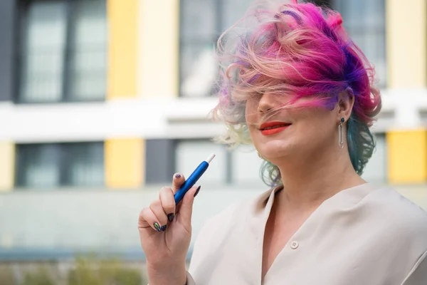색색 머리카락을 가진 백인 여자가 전자 담배를 피운다. — 스톡 사진