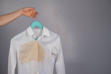 Beyaz arka planda kahve lekesi olan kadın ofis beyaz gömleği..