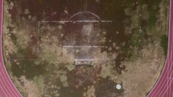 Vista dall'alto di un campo di calcio abbandonato. Filmato drone del vecchio stadio della scuola — Video Stock