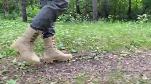 The woman is engaged in hiking in a pine forest. close-up of legs, — Stock Video