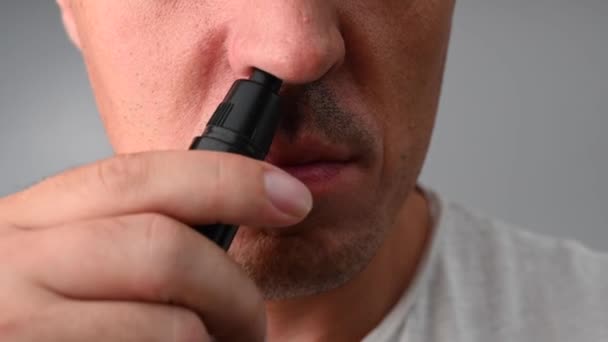 Un hombre se corta el pelo de la nariz con una recortadora de bolsillo — Vídeos de Stock