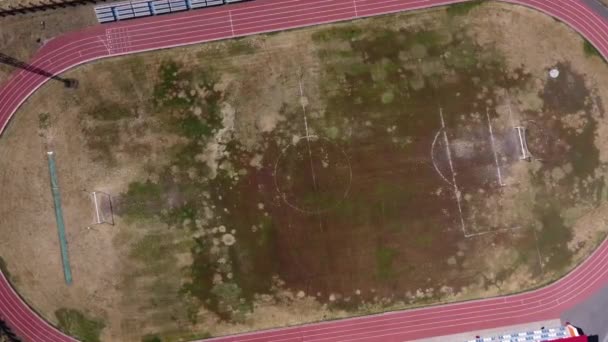 Horní pohled na opuštěné fotbalové hřiště. Dronové záběry ze starého školního stadionu — Stock video