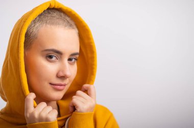 Beyaz arka planda, kapüşonlu genç bir kadın..