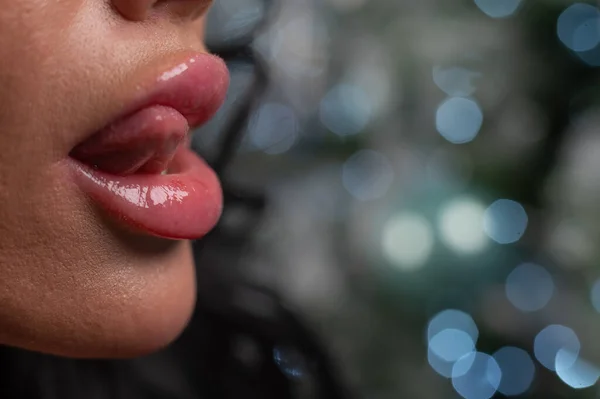 Großaufnahme großer dicker weiblicher Lippen vor weihnachtlichem Hintergrund. — Stockfoto
