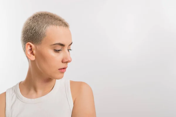 Mulher caucasiana jovem com cabelo curto em um fundo branco. — Fotografia de Stock