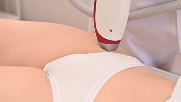 Uma mulher em um salão de beleza profissional remove vegetação indesejada na área do biquíni usando depilação a laser — Vídeo de Stock