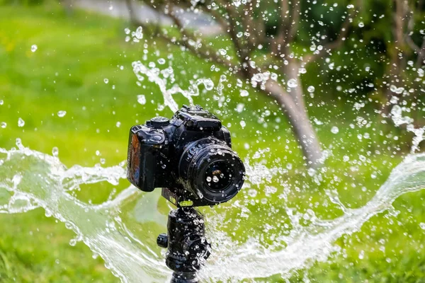 Una cámara digital en un trípode bajo la lluvia — Foto de Stock