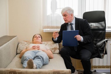 Kafkasyalı kadın bir psikoterapistle resepsiyonda kanepede yatıyor. Yaşlı bir adam psikiyatrist olarak çalışır.