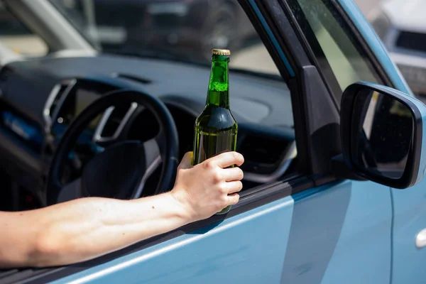 Yüzsüz bir kadın araba sürerken bir şişe bira içiyor. Kanunları çiğnemek ve araba kullanırken alkol içmek. — Stok fotoğraf