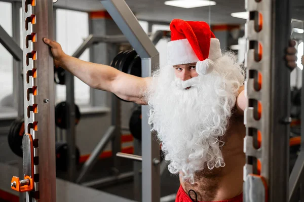 Tomten i gymmet. Muskulös man med naken överkropp som tränar med hantlar. — Stockfoto