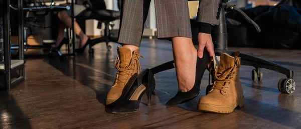 사업을 하는 여성은 사무실에서 부츠에 하이힐을 신고 신발을 갈아 신는다. 근무 시간의 끝. 피곤 한 다리 — 스톡 사진