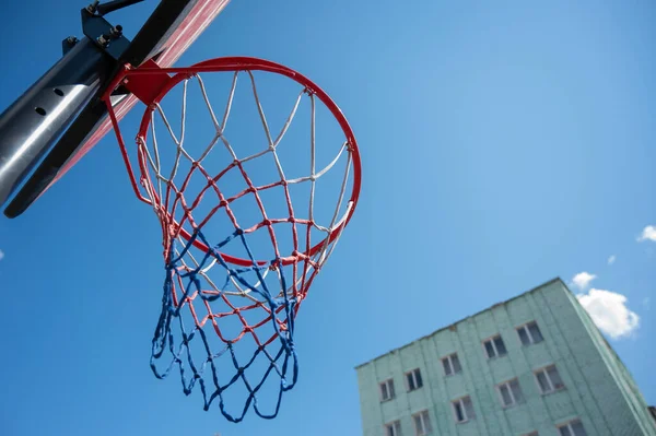 Vista in basso di un cestino da basket vuoto contro il cielo blu — Foto Stock