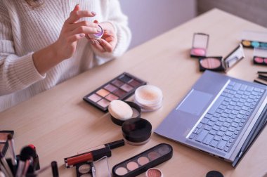 Yüzü olmayan bir kadın dizüstü bilgisayardaki profesyonel bir makyaj sanatçısından online eğitim izliyor. Uzaklık öğrenimi