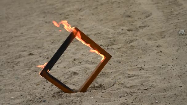 Marco de fotos de madera en llamas en la playa. — Vídeos de Stock