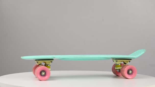 Penny board draaiend op een tafel op een witte achtergrond. — Stockvideo