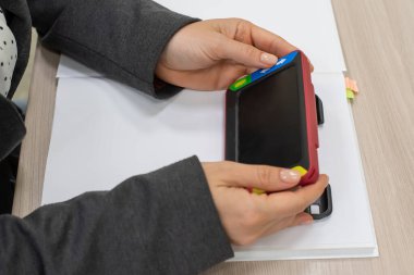 Kadın, görme engelliler için bir okuma cihazı tutuyor. Miyoplar için elektronik büyüteç