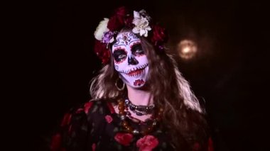 Siyah arka planda Noel Baba makyajlı bir kadın. Cadılar bayramı için geleneksel Meksika kutsal ölüm kostümü giyen bir kız. Boşluğu kopyala