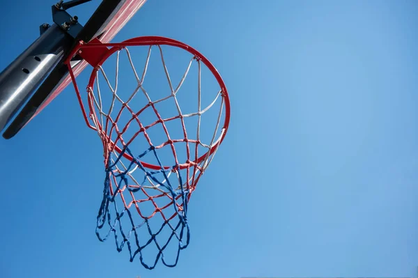 Vista in basso di un cestino da basket vuoto contro il cielo blu — Foto Stock