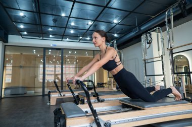 Kafkas kadın yenilikçi makineler üzerinde egzersiz yapıyor.