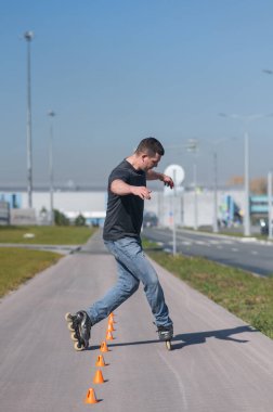 Beyaz bir adam slalom pistinde paten kayıyor.