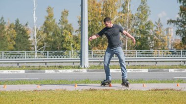 Beyaz bir adam slalom pistinde paten kayıyor.