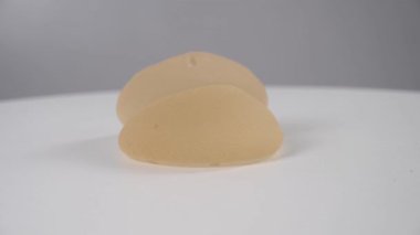 Beyaz bir arka planda iki silikon implant dönüyor.