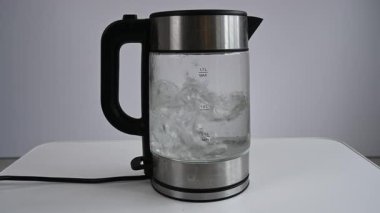 Cam elektrikli su ısıtıcısı kaynıyor. Sesli video