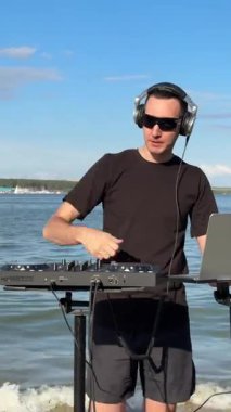 Beyaz adam plajda DJ olarak çalışıyor.