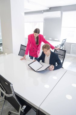 Beyaz kadın astlarına talimat veriyor.