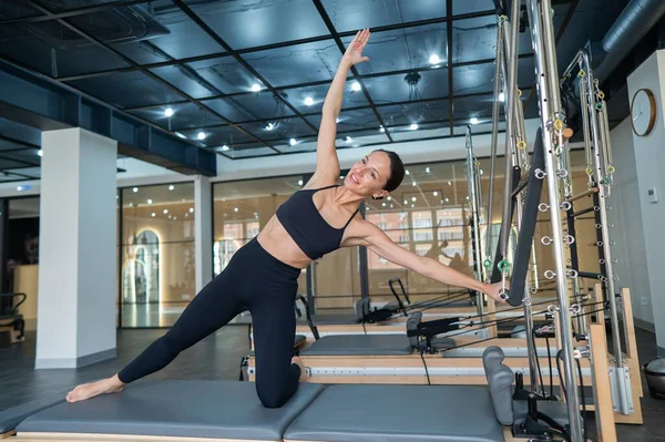 Kafkasyalı kadın yenilikçi makinede yan büküş yapıyor.