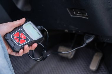 OBD2 tanı tarayıcısı kullanan kadın