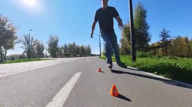 Beyaz bir adam slalom pistinde paten kayıyor.