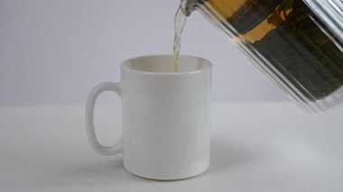 Bir adam çay makinesinden çay dolduruyor. Sesli video