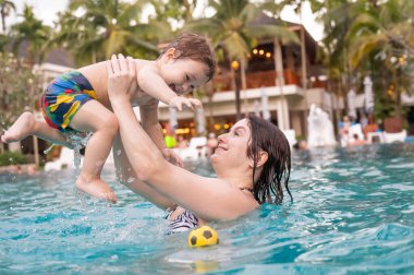 Beyaz kadın tatilde havuzda yüzerken oğlunu kucağına aldı