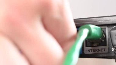 Yönlendiriciden kabloyu çıkaran kadın