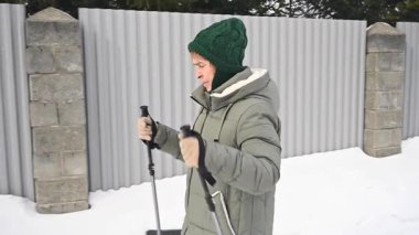 Kafkasyalı yaşlı kadın kışın İskandinav bastonlarıyla yürüyor