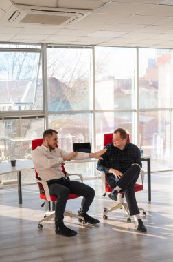 İki beyaz adam iş yerinde eğleniyor.