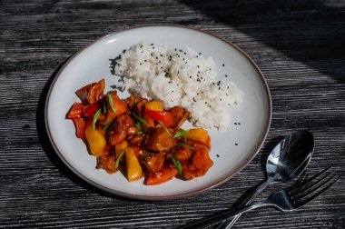 Tatlı ve ekşi soslu domuz eti ve tabakta haşlanmış pirinç.