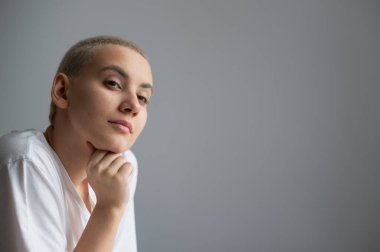 Kısa saçlı düşünceli genç bir kadının portresi. Boşluğu kopyala.