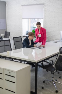 Beyaz kadın astlarına talimat veriyor.