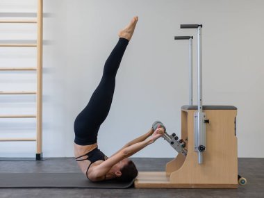 Beyaz kadın klasik sandalyede pilates yapıyor.