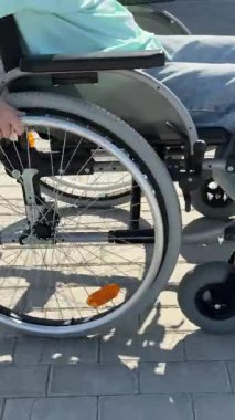 Tekerlekli sandalyedeki bir kadının ellerine yakından bakın.