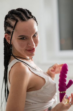 Caucasian woman holding a pink dildo